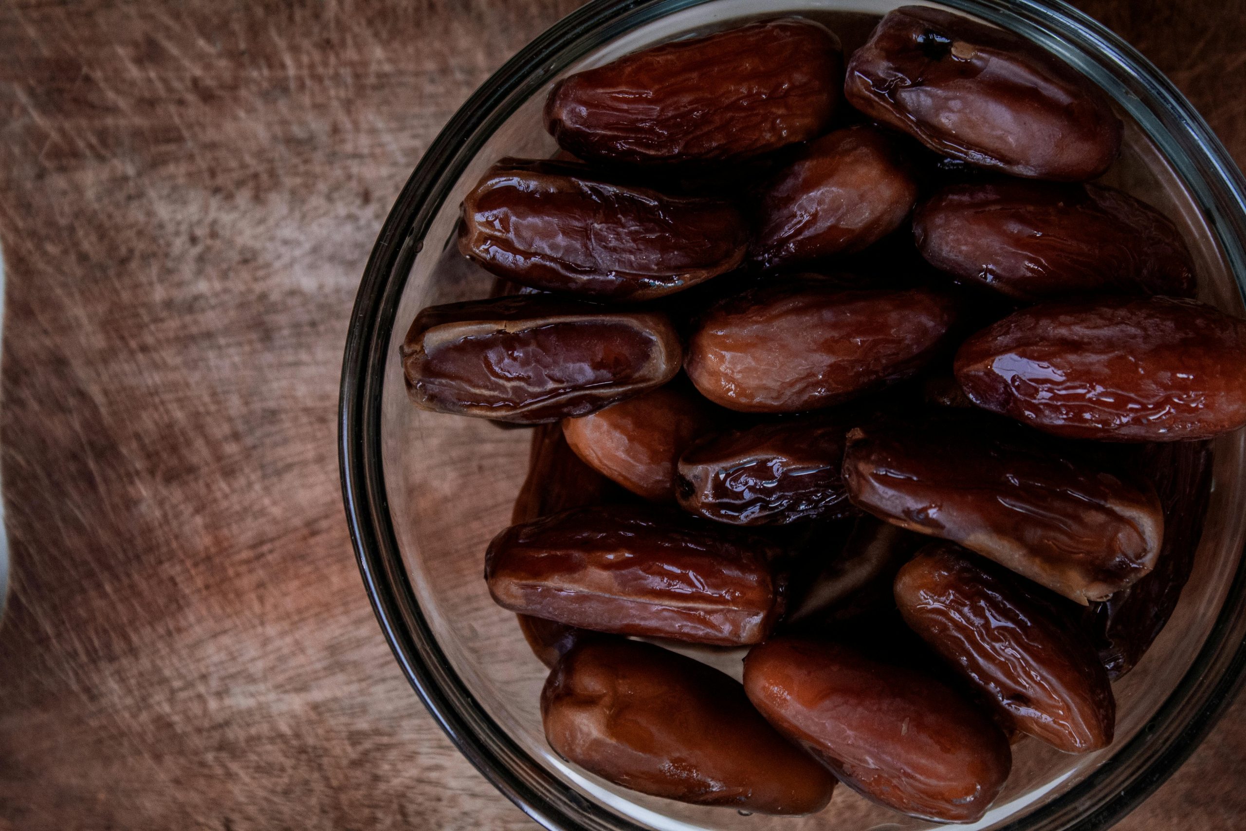 A close-up view of dates in a glass bowl, perfect for Ramadan or natural snack themes.