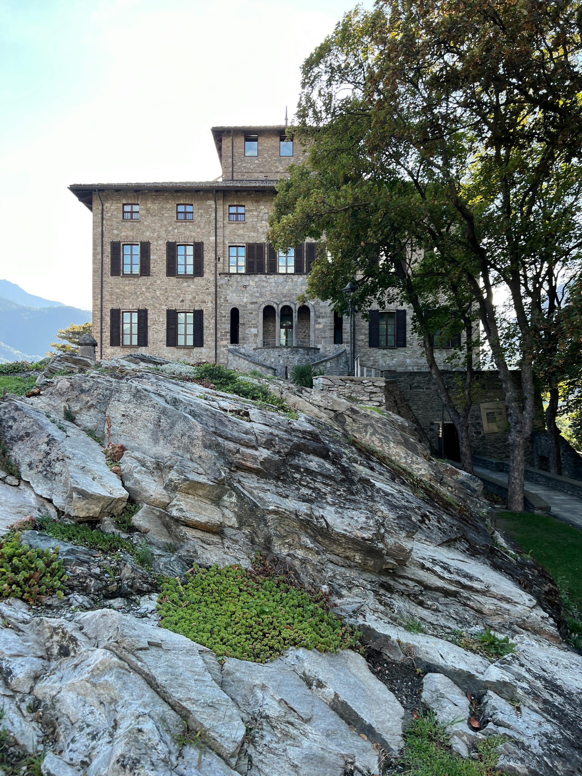 Stone castle with rocky landscape and trees in Italy, scenic view.